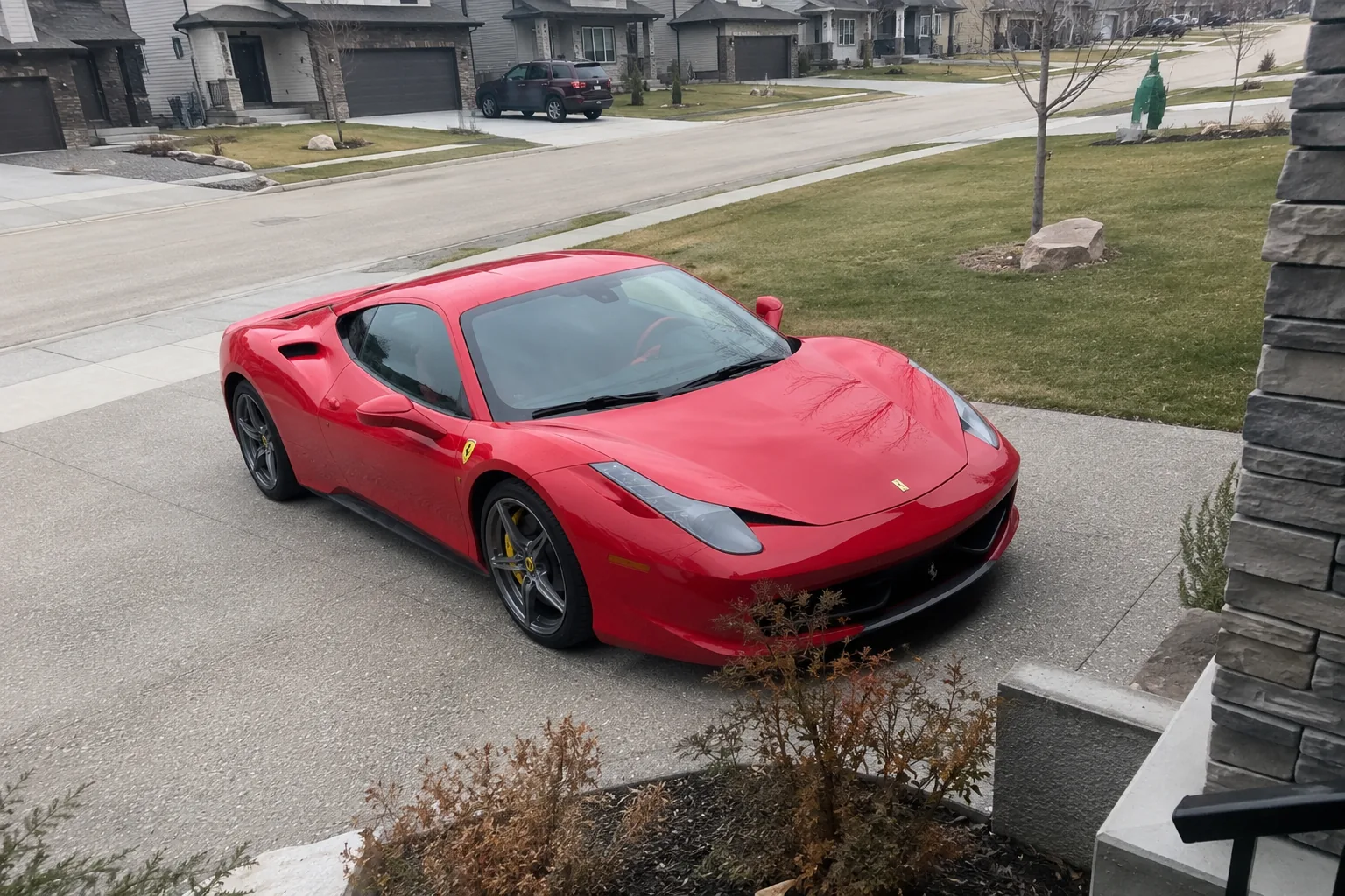 Illustrative editorial photo: a red sports car in an ordinary suburban driveway or street; quiet residential setting, no showroom or luxury campaign look.